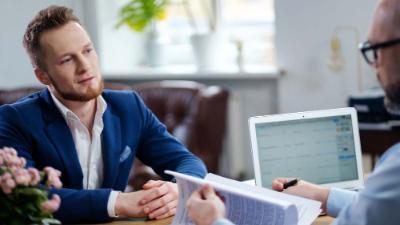 Man is speaking while looking at the interviewer