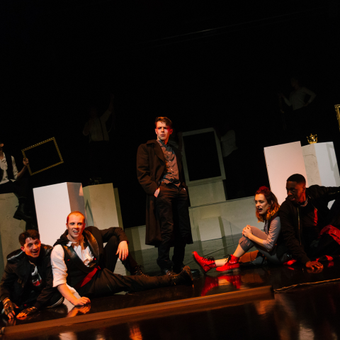 Plymouth Marjon students sit on a stage in a performance