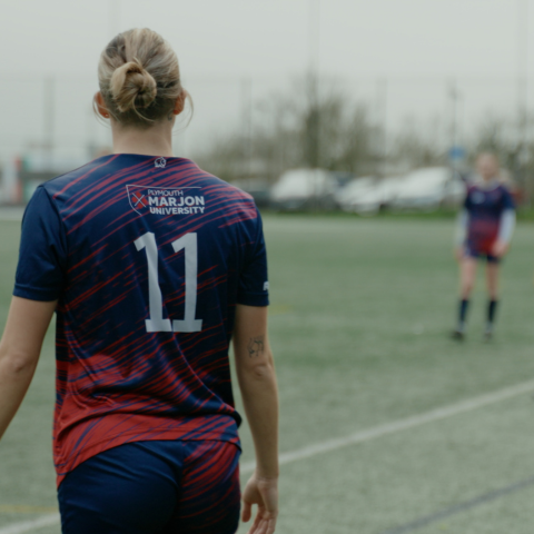 Female Marjon football player facing the pitch