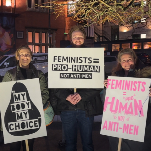 Three participants in the Reclaim the Night march holding signs