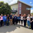 Group of smiling students outside health and wellbeing hub building